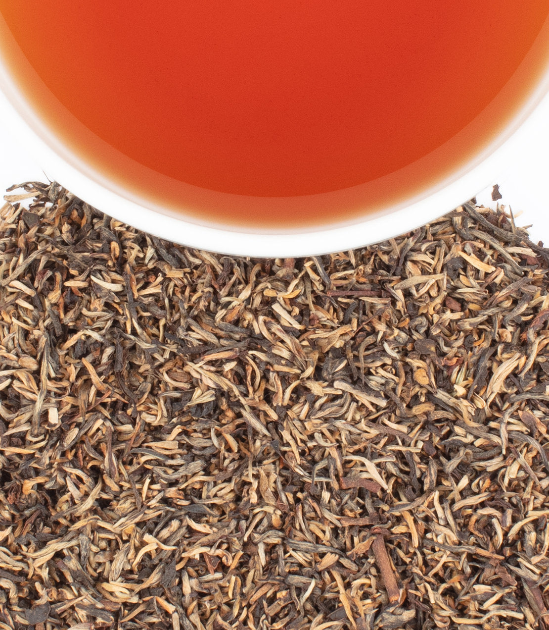 Chamraj Golden Tips tea leaves with a cup of brewed tea, showcasing rich color and fine quality.