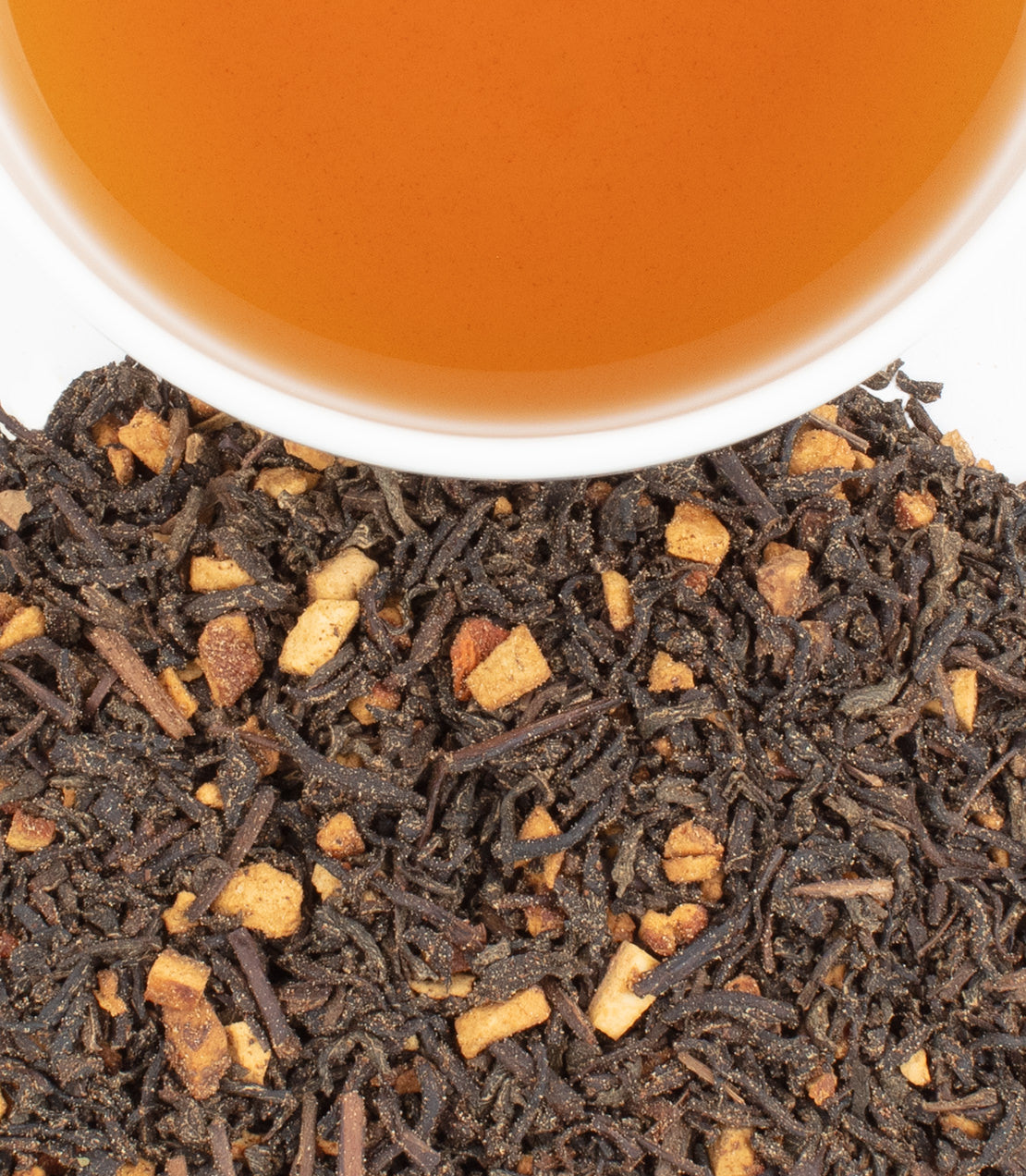 Decaf Hot Cinnamon Spice tea sachets with loose tea leaves and a cup of brewed tea above.