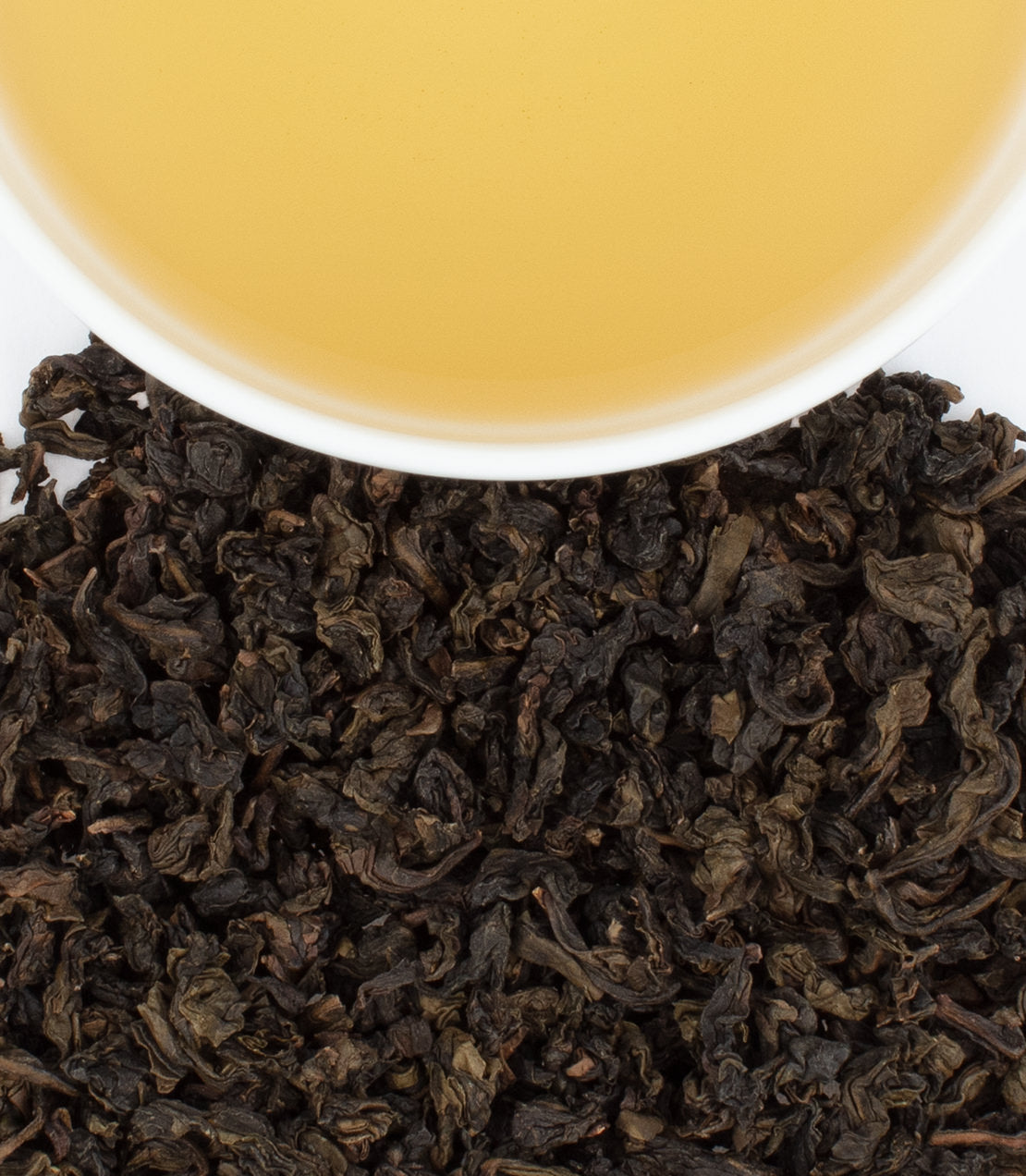 Nong Ti Quan Yin tea leaves with brewed tea in a cup, showcasing rich color and texture.