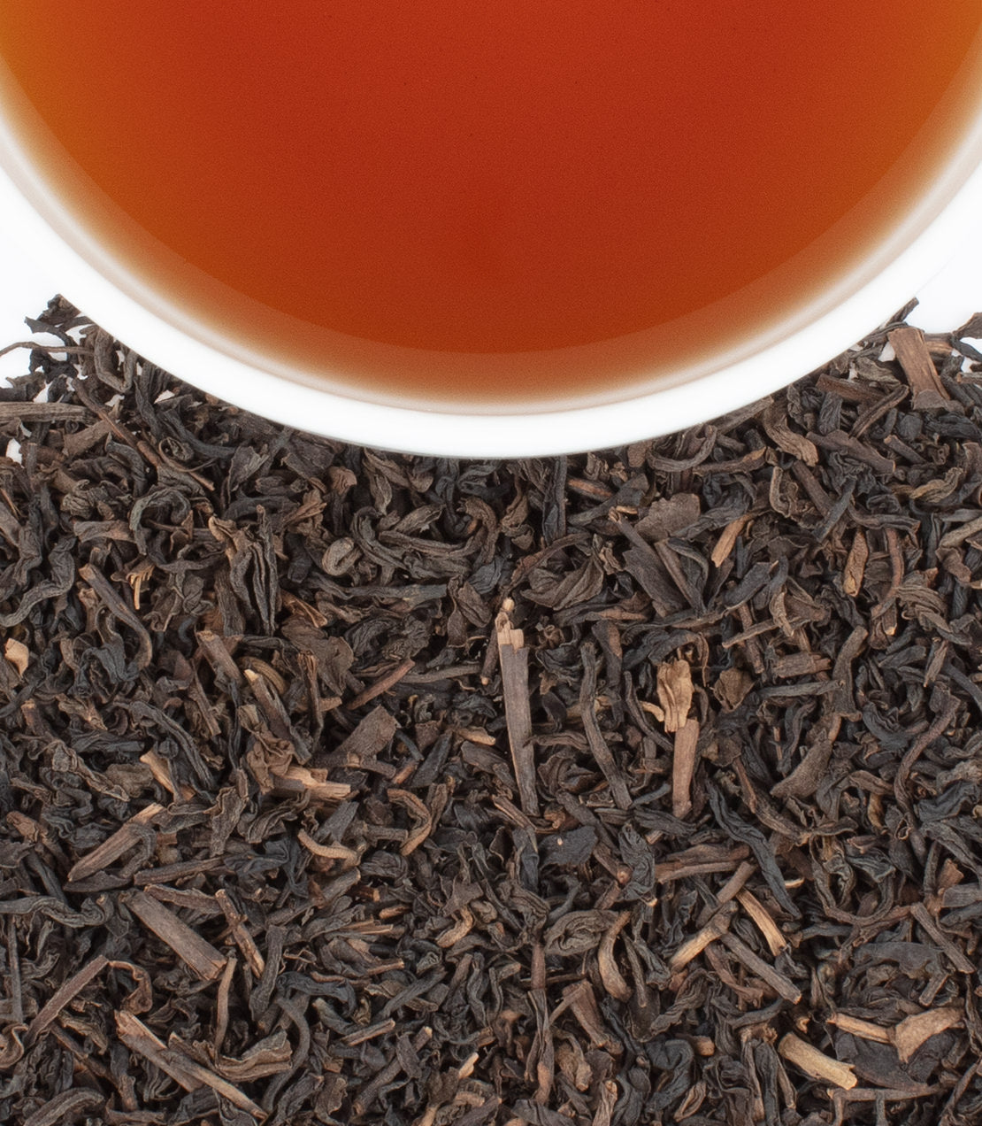 Decaf Ceylon tea sachets, 50-count bag, with brewed tea and loose leaves displayed. Rich flavor and aroma.