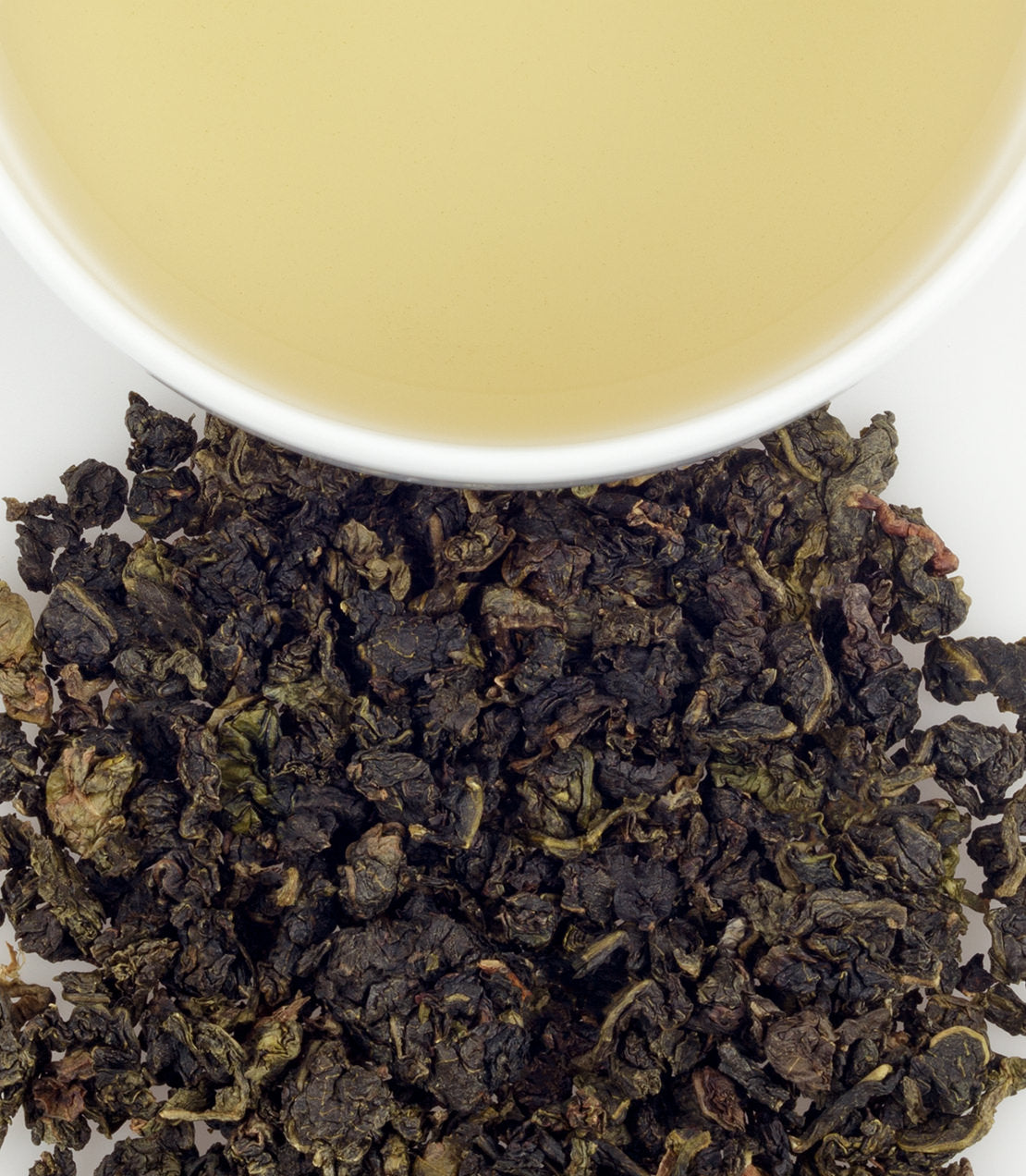 Milky Oolong tea sachets in a tin, with brewed tea and loose leaves displayed. Rich flavor and aroma.