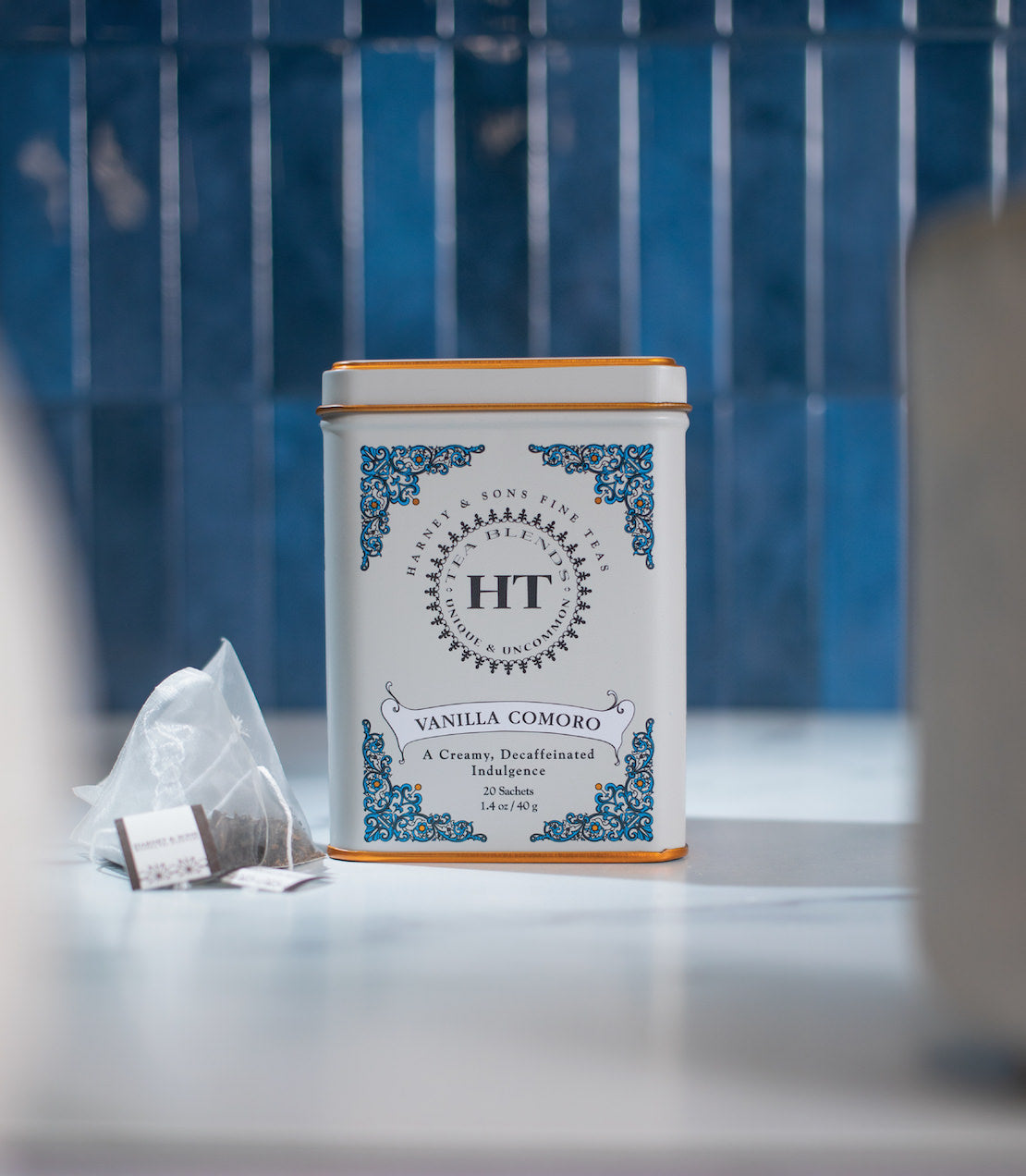 Decaf Vanilla Comoro tea tin with 20 sachets, featuring elegant design and creamy flavor description.