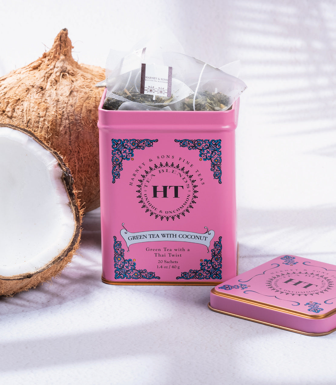Pink tin of HT Green Tea with Coconut, featuring 20 tea sachets, displayed with a coconut shell.
