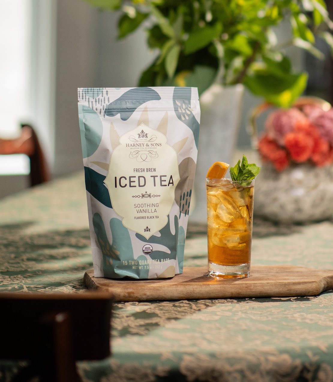 Harney & Sons Soothing Vanila Fresh Brew iced tea package on a table with a glass of iced tea.