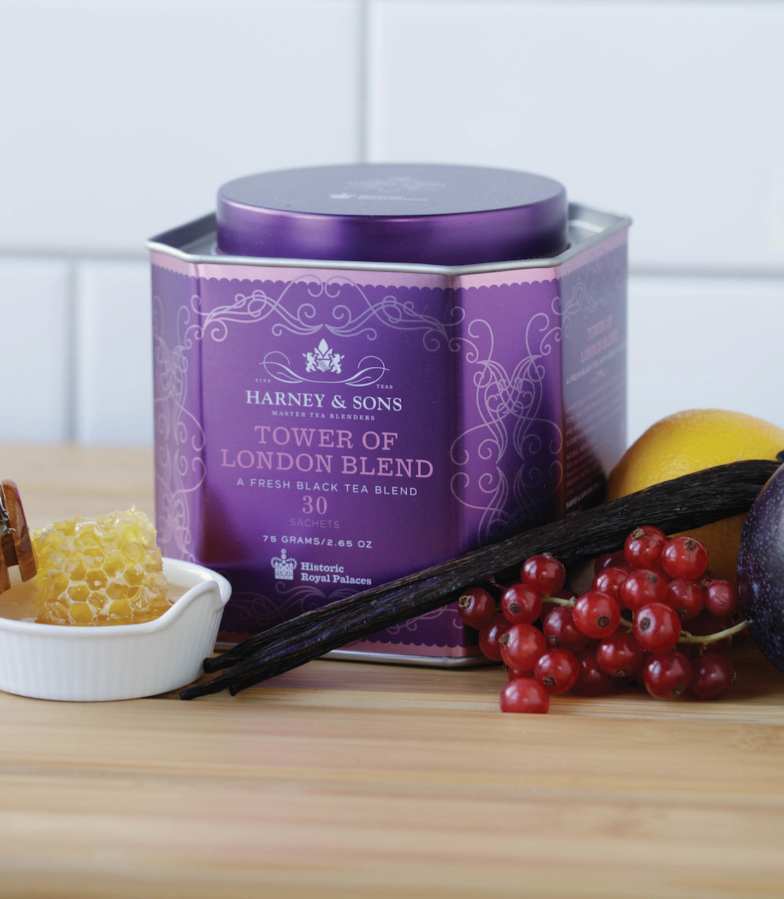 Harney & Sons Tower of London Blend tea tin with 30 sachets, surrounded by honey, fruit, and vanilla.