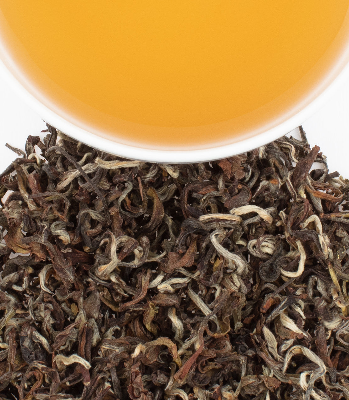 Himalayan Bouquet tea leaves with brewed tea in a white cup, showcasing rich colors and textures.