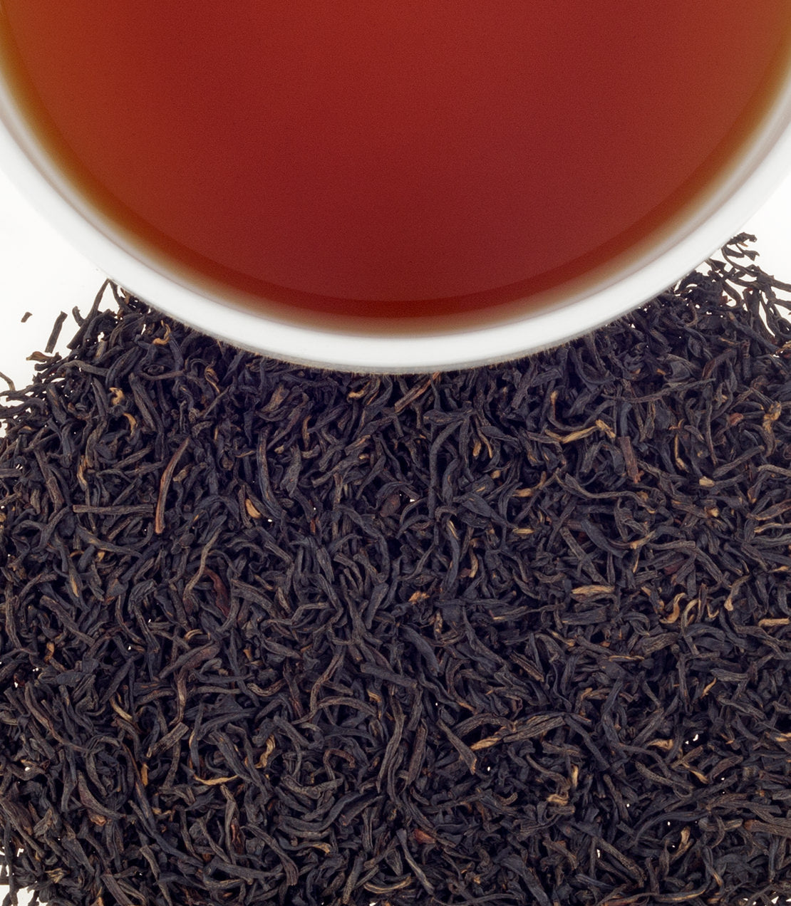 Hao Ya 'A' black tea leaves with brewed tea in a white cup, showcasing rich color and texture.