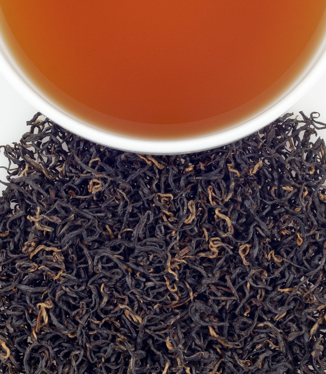 Keemun Mao Feng tea leaves with a cup of brewed tea, showcasing rich color and fine, twisted leaves.