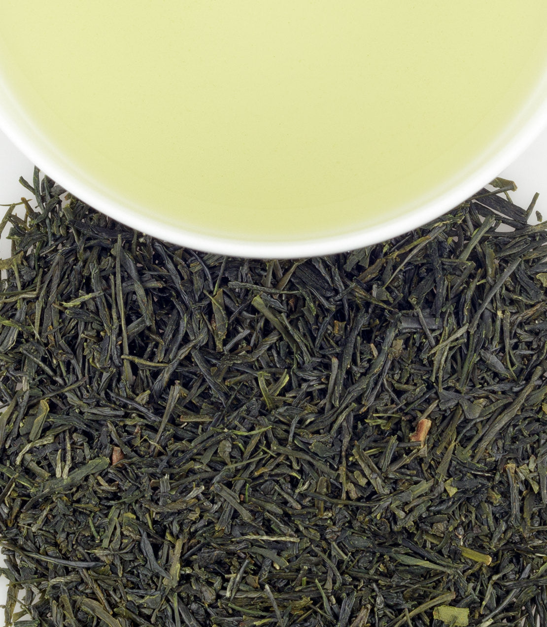 Matsuda’s Sencha green tea leaves with a cup of brewed tea, showcasing vibrant green hues and rich texture.