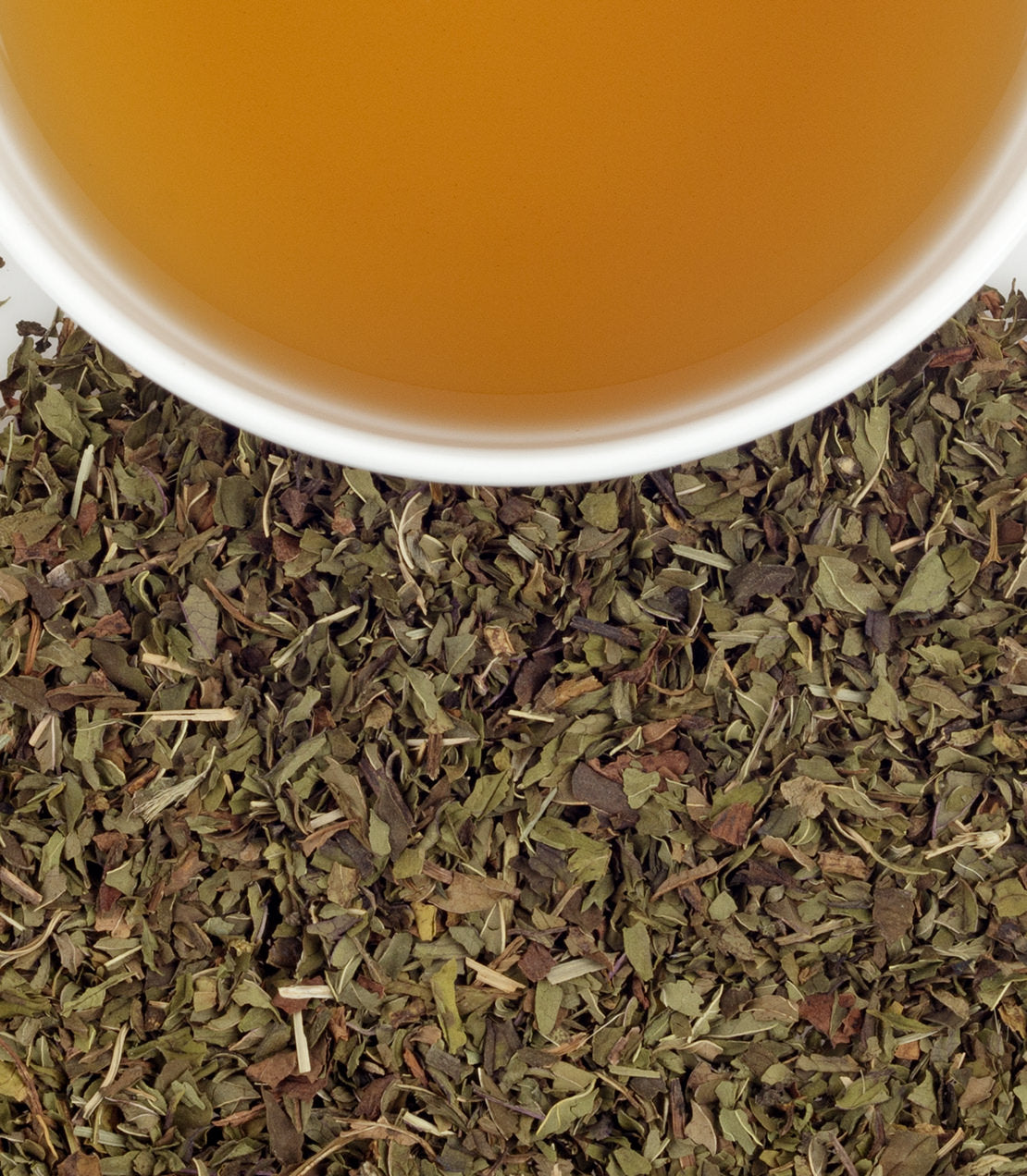 Peppermint herbal tea sachets in a tin, with a cup of brewed tea and dried peppermint leaves.