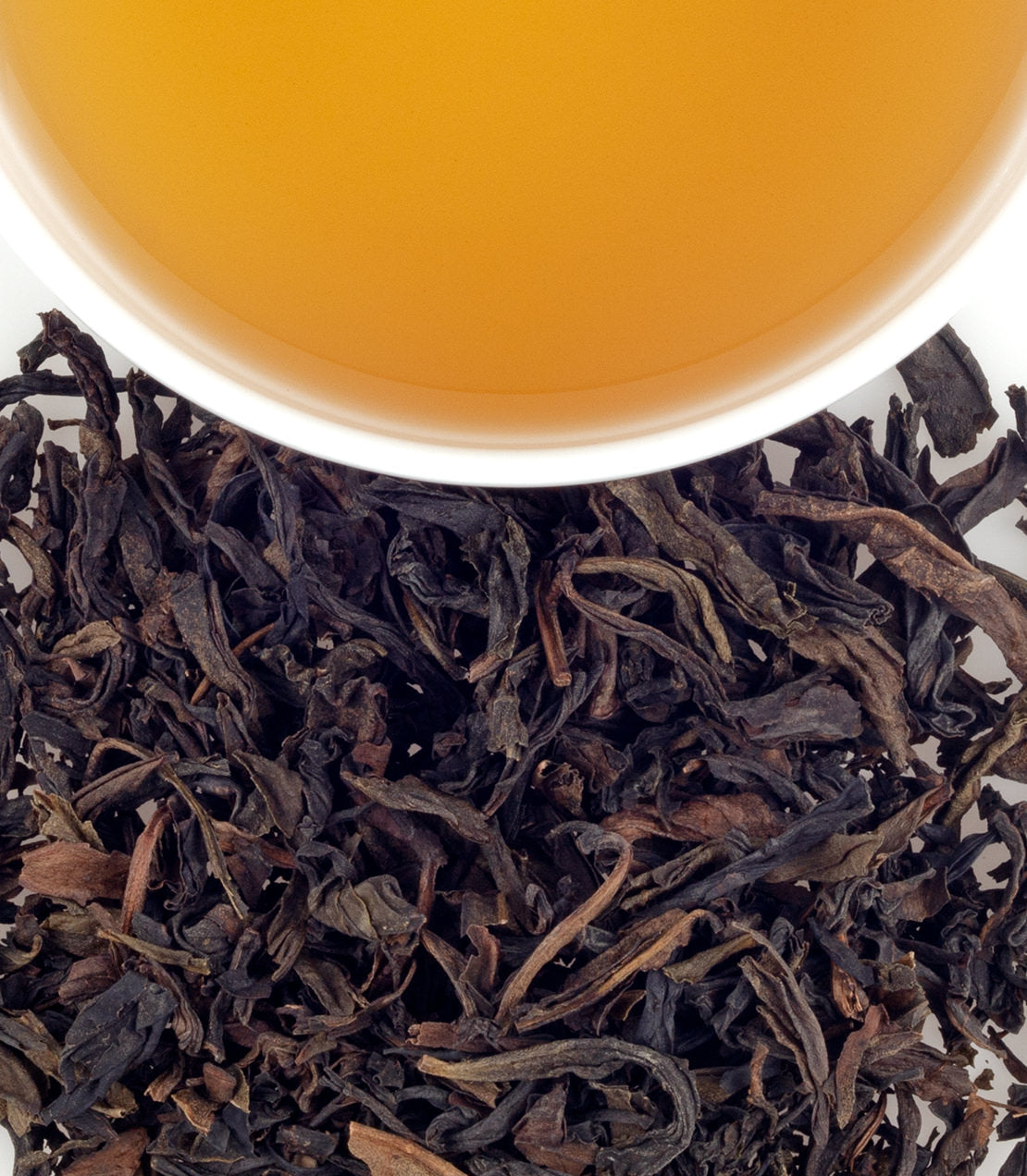 Rou Gui Oolong tea leaves with brewed tea in a cup, showcasing rich colors and textures. Perfect for tea enthusiasts.