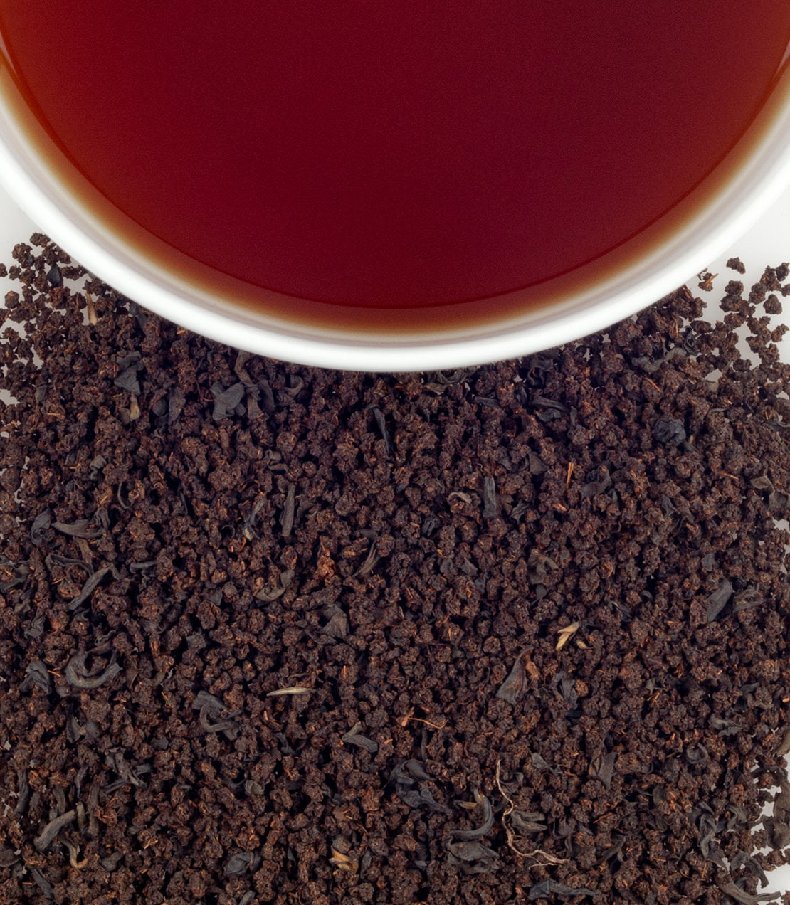 Scottish Morn tea sachets with brewed tea in a cup, surrounded by loose tea leaves. Perfect for a morning boost.