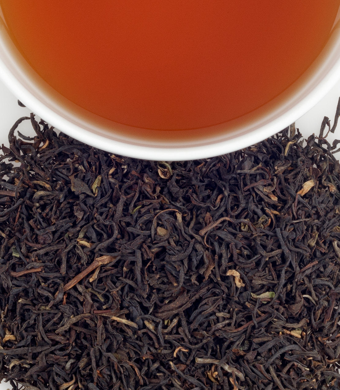 A close-up of Stanley's Blend tea leaves with a cup of brewed tea, showcasing rich colors and textures.
