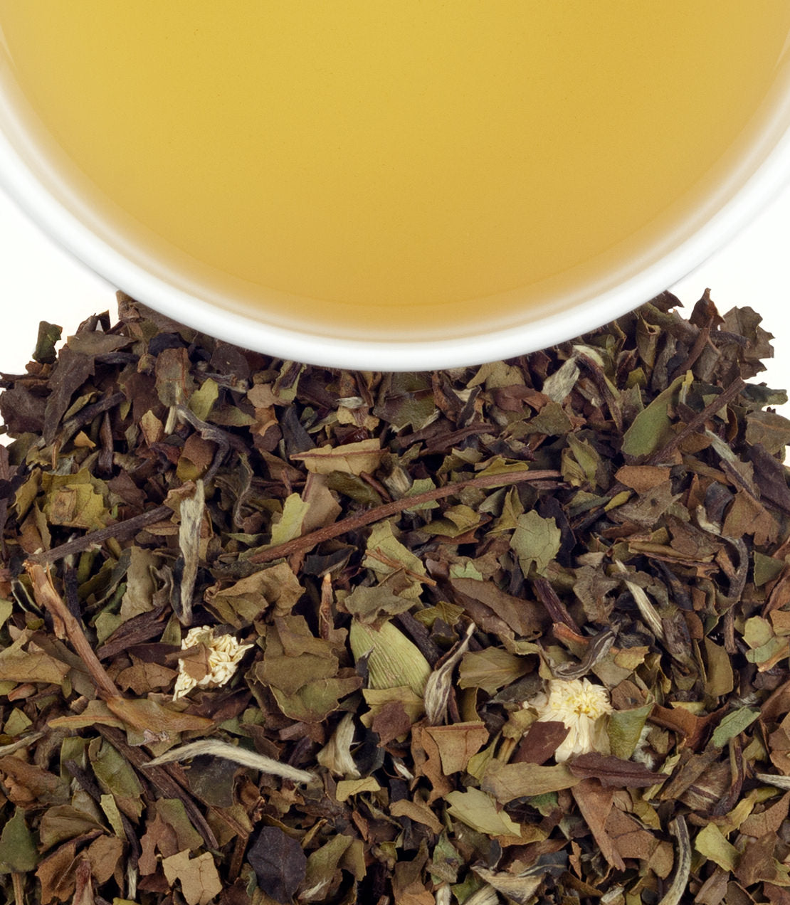 White Christmas Tea sachets with brewed tea in a cup, showcasing herbal blend and warm golden color.