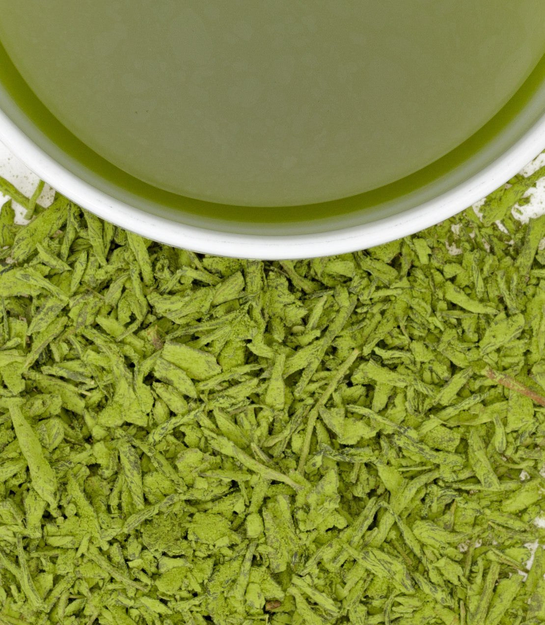 Very Berry Matcha sachets with vibrant green tea leaves and a cup of brewed matcha above. Perfect for a refreshing drink.